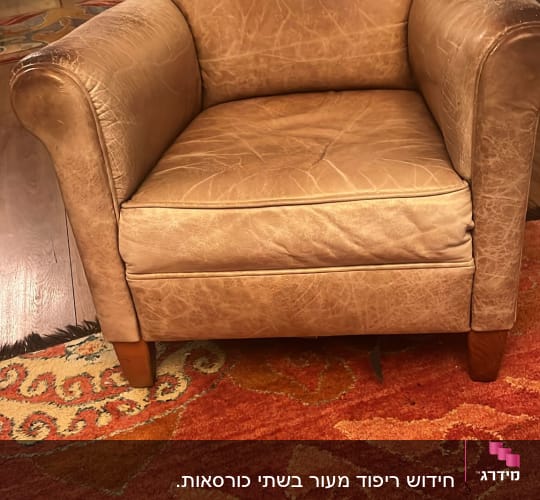 כורסה מרופדת בעור חום עם כרית מושב